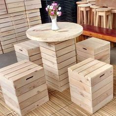 several wooden boxes stacked on top of each other next to a vase with flowers in it