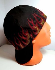 a mannequin head wearing a black hat with red flames on it