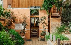 an entrance to a building with plants growing on the outside wall and wooden steps leading up to it