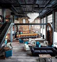 the interior of a restaurant with blue couches and white chairs in front of a brick wall