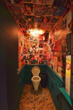 there is a toilet in the corner of this room with many pictures on the walls