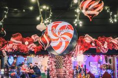 a candy bar decorated for christmas with lights and decorations hanging from the ceiling above it