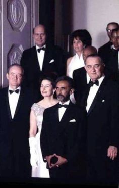 a group of people in tuxedos posing for a photo