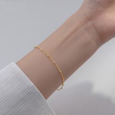 Our lightweight Minimal Satellite Chain Bracelet brings a fresh feel to your wardrobe. Simple and shimmery, this bracelet begs to be layered with others but can be worn alone for a minimal, polished look. DETAILS & SIZE Finish: 18K gold or rose gold plate, Sterling silver Material: .925 sterling silver Measurements: Beads: 2mm; Chain: 7" Lobster claw clasp Shop Bracelets for more options to layer it with! Complete the Look with the Matching Necklace! Delicate Gold Bangle Chain Bracelet, Modern Bracelets With Satellite Chain, Minimalist Hypoallergenic Gold Plated Chain Bracelet, Modern Satellite Chain Bracelets, Hypoallergenic Minimalist Gold Plated Chain Bracelet, Minimalist Chain Bracelets, Delicate Gold Satellite Chain Bracelet, Minimalist Gold Chain Bangle Bracelet, Minimalist Gold Bracelet With Satellite Chain