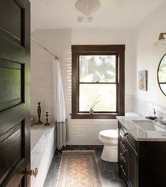 a bathroom with wood floors and white walls