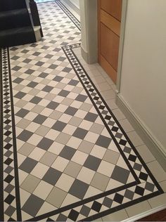 a black and white checkered floor in a hallway with an open door to another room