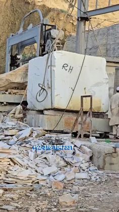 a man standing in front of a pile of rubble next to a large white container