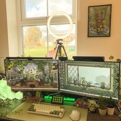 two computer monitors sitting on top of a desk next to a keyboard and monitor screen