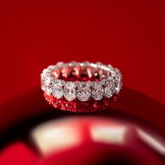 a diamond ring sitting on top of a red surface