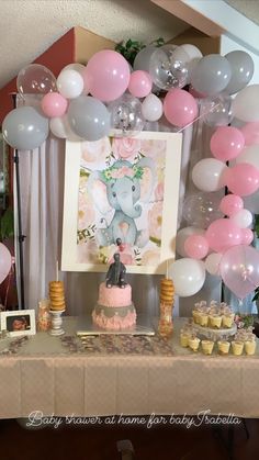 an elephant themed birthday party with balloons, cake and cupcakes on the table