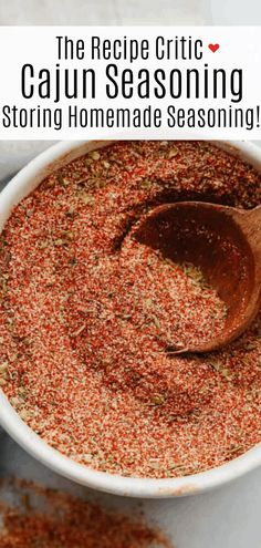 the recipe for cajun seasoning is in a white bowl with a wooden spoon