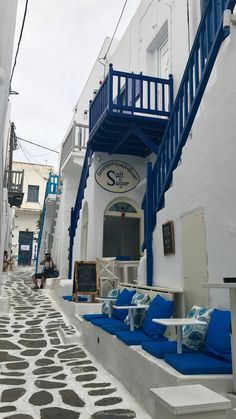 an alleyway with blue and white painted steps leading up to the building's entrance