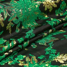 green and gold leaves on black fabric with metallic foiled details, closeup view