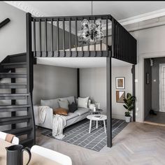 a living room filled with furniture and a spiral staircase leading up to the top floor