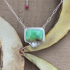 Wow!  Look at how well these gemstones go together! This pendant features a 23mm x 16mm rectangle shaped chrysoprase cabochon. I bezel set this gem in fine and recycled sterling silver. The back of the bezel has been embossed with flowers. Below the stone, I have flush-set two faceted 2mm rhodolite garnet gemstones. There is also a silver disc with a stamped dandelion. The entire pendant is 1.1" wide and 1.1" tall. This pendant has been lightly oxidized and has a brushed finish. The pendant is a Unique Chrysoprase Gemstone Necklace, Artisan Chrysoprase Necklaces For Jewelry Making, One-of-a-kind Green Chrysoprase Necklace, Chrysoprase Gemstone Pendant Jewelry, Silver Chrysoprase Gemstone Necklace, Artisan Chrysoprase Gemstone Jewelry, Chrysoprase Emerald Necklace For Gift, Ruby Beads, Rhodolite Garnet