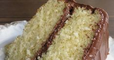 a piece of cake with chocolate icing and coconut on top sitting on a plate