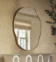 a mirror hanging on the wall above a shelf