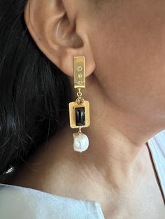 These stunning statement earrings are crafted using premium materials, including brass, copper, Baroque pearl, black onyx stone and gold plating. Their bold and elegant design ensures they will stand out, making them perfect for special occasions or adding a touch of luxury to any outfit. Earrings Weight: 18 grams per pair Materials: Brass, Copper, black onyx Stone, Baroque pearl, CZ Stones, Gold Plating Size Details: Length is 7.5 cm and width is 1.5 cm. Push Back Closure. These earrings are sure to attract compliments, offering both sophistication and timeless beauty. Luxury Statement Brass Pearl Earrings, Luxury Baroque Earrings, Luxury Elegant Onyx Earrings, Black Onyx Stone, Onyx Stone, Baroque Pearls, Cz Stone, Black Onyx, Gold Plating