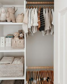 an organized closet with clothes, toys and other items in baskets on the bottom shelf