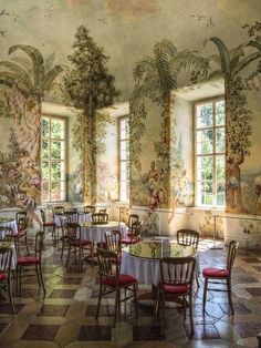 a dining room with tables and chairs in front of two large paintings on the walls