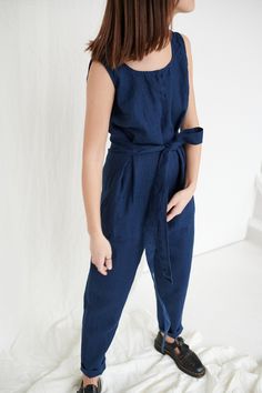 "The sleeveless jumpsuit Evelyn is one of our first jumpsuits, and it is so loved because if its simple cut. The deep V-neckline in the back and two attached waist ties give some charm to this figure-flattering silhouette. This garment is true to size, and we recommend choosing the size you usually wear. If you want the garment to be loose-fitting, choose a larger size than you usually wear. Before placing an order, check the approximate measurements of the finished garment given below. Model is Cotton Jumpsuit With Tie Waist And Relaxed Fit, Relaxed Fit Cotton Jumpsuits And Rompers With Tie Waist, Relaxed Fit Cotton Jumpsuit With Tie Waist, Relaxed Fit Jumpsuits And Rompers With Tie Waist, Navy Jumpsuits And Rompers With Pockets, Navy Jumpsuits And Rompers With Pockets For Spring, Navy Jumpsuits And Rompers For Work In Summer, Spring Navy Jumpsuits And Rompers With Pockets, Fitted Linen Jumpsuits And Rompers With Pockets