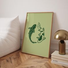 there is a framed photo on the floor next to books and a lamp with a fish drawn on it