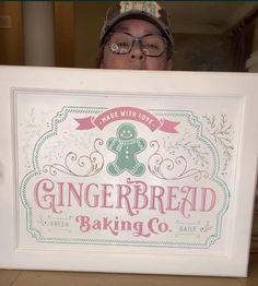 a woman holding up a sign that says gingerbread baking co