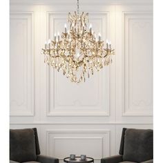 a chandelier hanging from the ceiling in a room with two chairs and a table