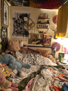 there are many stuffed animals laying on the bed in this room with pictures above it