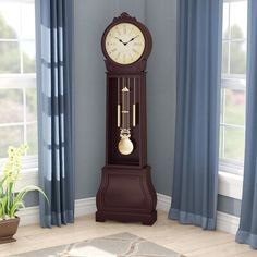 a grandfather clock sitting in the corner of a room with blue drapes and curtains