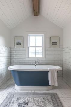 a bathroom with a blue bathtub and rug