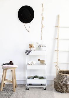 a white shelf with books and hats on it