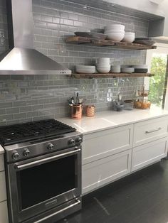 a stove top oven sitting inside of a kitchen next to a wall mounted range hood