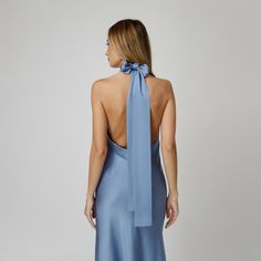 A captivating blend of elegance and allure, our Skye Open Back Halter Dress exudes undeniable charm. Tailored with a flattering bias cut from blue double silk satin, it drapes gracefully over the silhouette. The halter neckline delicately frames the shoulders, while the revealing back adds a note of sensuality. For a playful and feminine look, you can transform the silk tie neck into a chic bow, or you can let it drape loosely, adding a touch of laid-back sophistication to your ensemble.  Wear it with flats for an effortlessly refined look or dress it up with a precious pair of heels. Each Il Volo item is handmade by skilful artisans in our Bucharest atelier and it is created in limited series. 100% Italian Double Silk Satin.  Gentle dry clean. Do not wash. Do not use chlorine based bleach Elegant Bias Cut Dress For Wedding Guest, Blue Slip Dress For Gala, Blue Evening Dress With Satin Finish For Weddings, Blue Satin Finish Evening Dress For Wedding, Blue Satin Slip Dress For Gala, Elegant Tie Back Satin Dress For Evening, Blue Satin Backless Midi Dress, Elegant Blue Tie Back Slip Dress, Elegant Tie-back Slip Dress For Formal Occasions