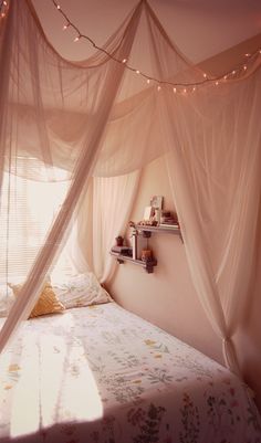 a bed with a white canopy over it and some lights on the wall above it