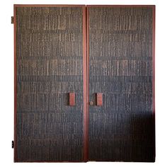 two wooden doors with metal handles on each side and one door open to show the same pattern