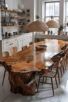 a wooden table surrounded by chairs in a room with white walls and wood flooring