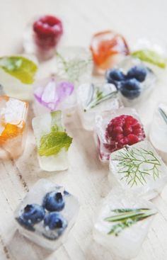 small ice cubes with berries and herbs on them