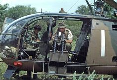 two men sitting in the cockpit of a helicopter