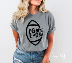 a woman wearing a gray game day t - shirt