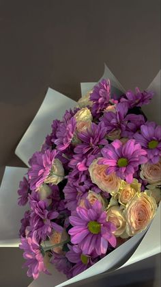 a bouquet of purple and white flowers in a vase