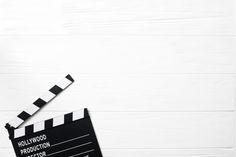 a movie clapper sitting on top of a white table next to a cup of coffee