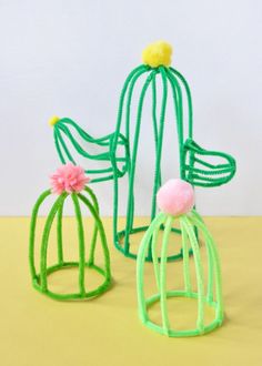 two green wire sculptures sitting on top of a table