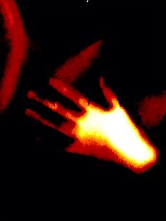 a blurry image of someones hand with their arm extended in the air, on a black background