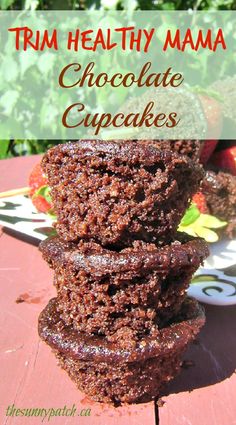 chocolate cupcakes stacked on top of each other with strawberries in the background