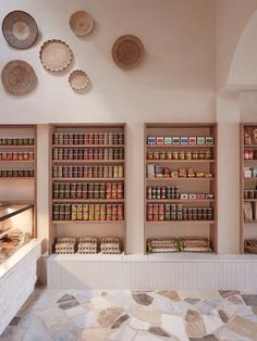 an empty store with lots of shelves and plates on the wall