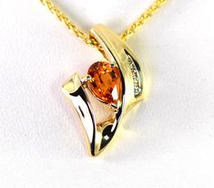 A fiery tangerine Spessartite Mandarin Garnet is accented with four graduated Diamonds in a pendant slide in 14k yellow gold. Spessartite, a rare form of garnet, also called mandarin or Malaya garnet, ranges from a yellow-orange through brilliant orange to orange-red. They combine very good hardness with excellent brilliance and sparkle. Spessartite are from Africa and are completely natural. Metal: 14k yellow Gold The spessartite is a 9 x 6mm pear shape from Africa with a weight of 1.60 carats. Orange Pear-shaped Jewelry, Orange Teardrop Anniversary Jewelry, Orange Fine Jewelry With Polished Finish, Elegant Pear-shaped Orange Jewelry, Elegant Orange Pear-shaped Jewelry, Fine Jewelry Orange Necklaces For Anniversary, Fine Jewelry With Orange Accent Stones, Orange Fine Jewelry With Accent Stones, Pear-shaped Orange Jewelry Gift