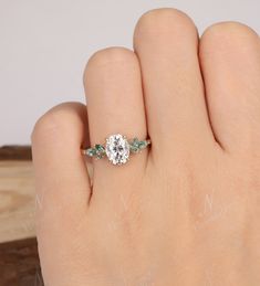 a person's hand with a ring on it and a diamond in the middle