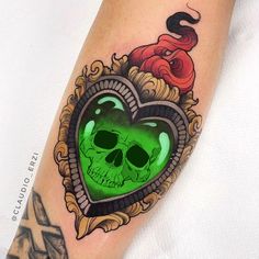 a green heart shaped tattoo with skulls on it's arm and an octopus in the background