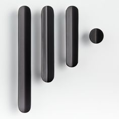 three black handles and two knobs on a white surface, with one pointing upward